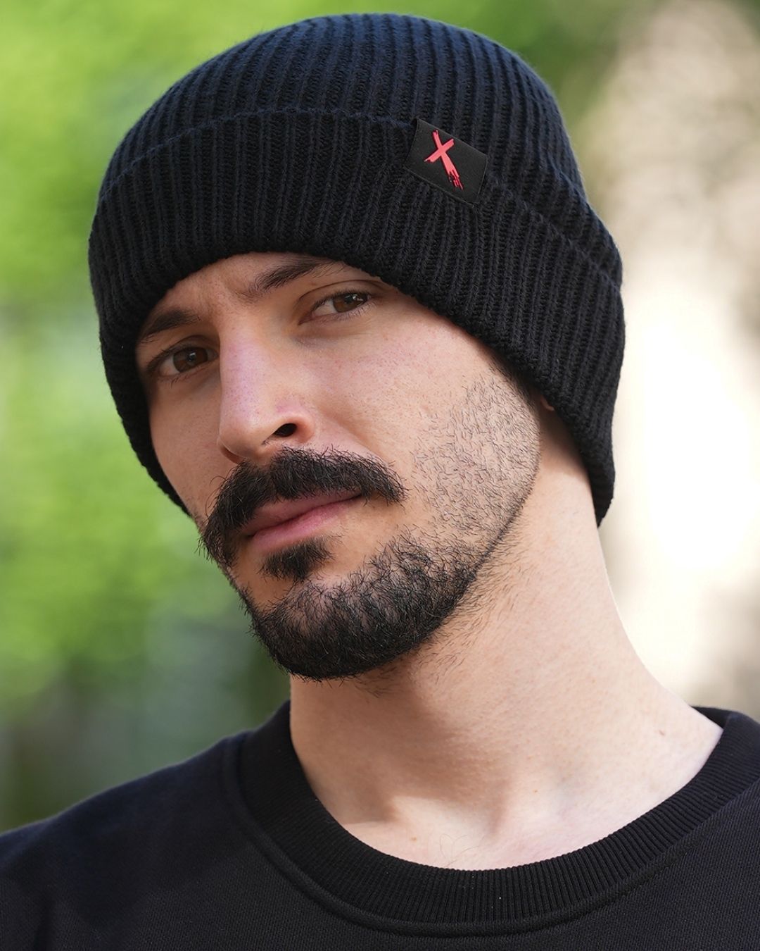 Le bonnet XSite noir, pris légèrement de profil, porté par Théo