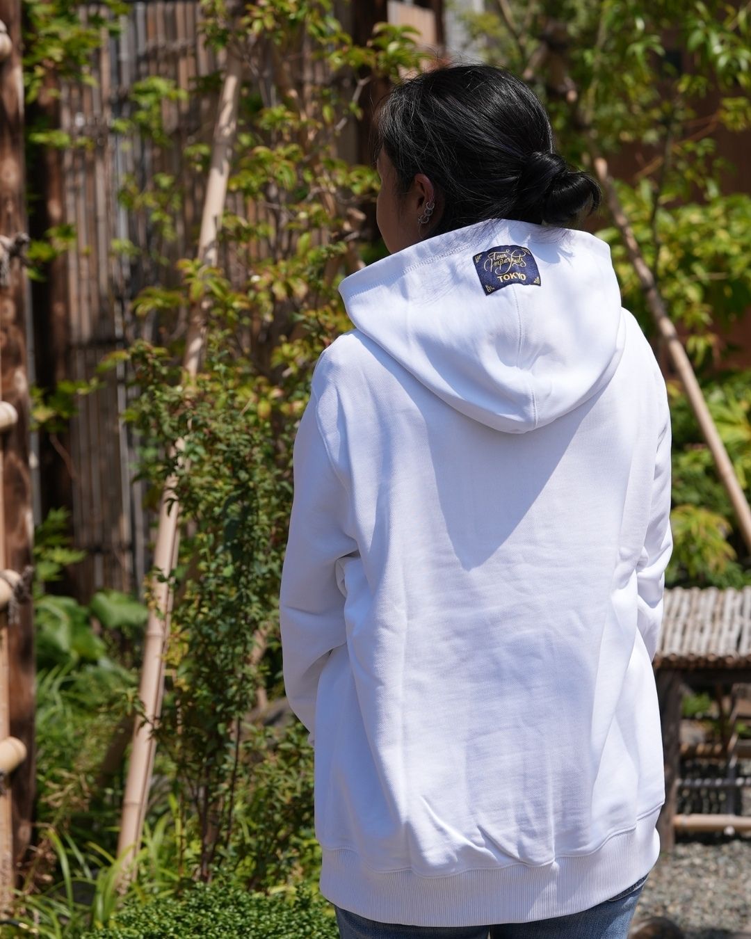 Akiko de dos, portant le hoodie Basics blanc de Tous Imparfaits