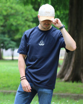Léo portant le t-shirt bleu Basics de Tous Imparfaits, photo prise de face, avec la casquette beige Tous Imparfaits