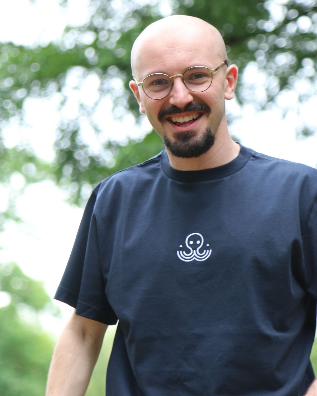 Théo souriant en portant le t-shirt bleu Basics