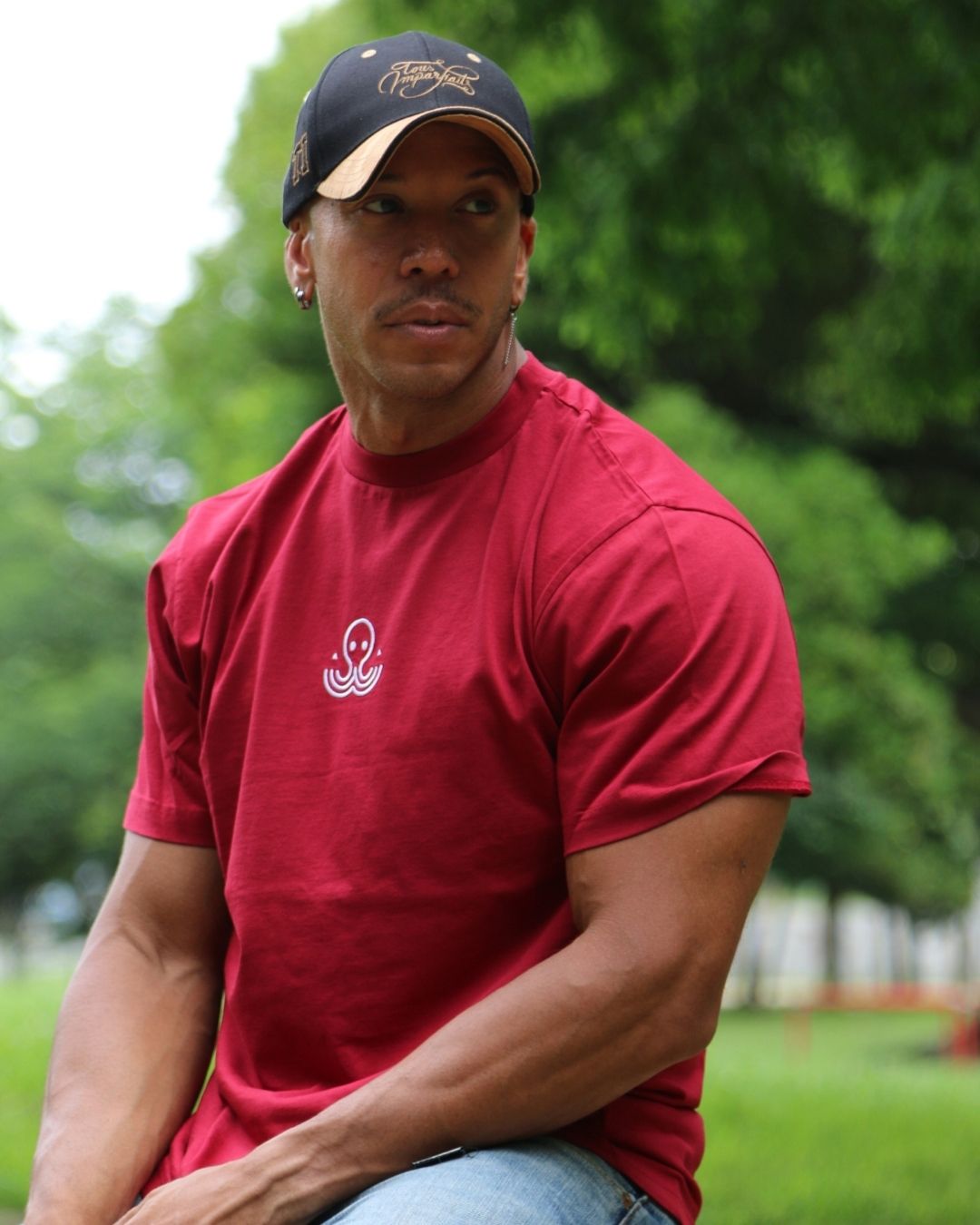 T-shirt IJC basic rouge, porté par JC assis