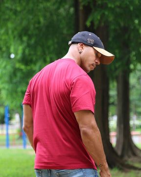T-shirt IJC basic rouge, porté par JC de dos dans un parc