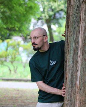 T-shirt IJC Basic vert, porté par Théo, caché derrière un arbre